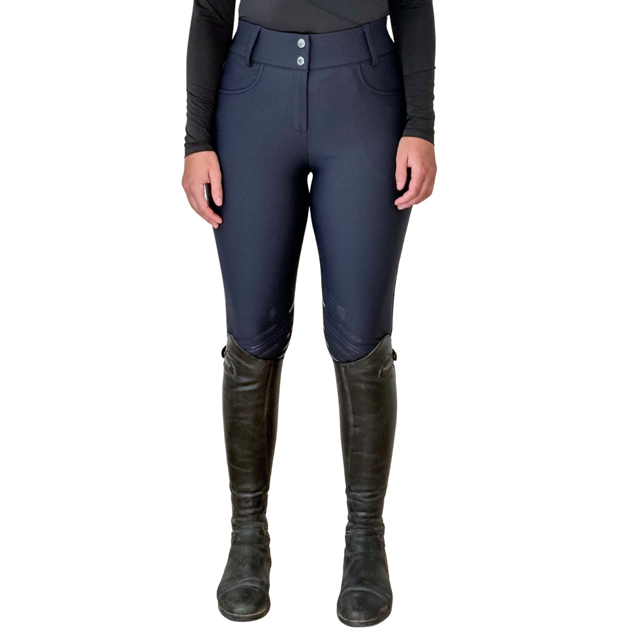 Person wearing navy riding pants with a black top and boots on a white background